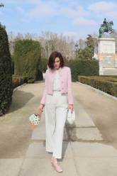 a lady wears a pink crop jacket with white blouse and white pants